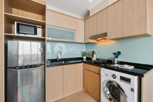 a kitchen with a washing machine and a washer at Alden by Kozystay - Menteng in Jakarta