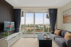a living room with a couch and a tv at Alden by Kozystay - Menteng in Jakarta