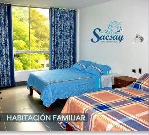 a bedroom with two beds and a sign on the wall at Sacsay Mejía in Islay