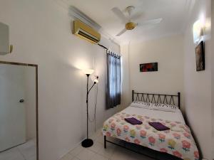 ein Schlafzimmer mit einem Bett und einem Deckenventilator in der Unterkunft Penang Tg Bungah Permai Ria Apartment in Tanjung Bungah