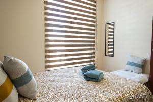 ein Schlafzimmer mit einem Bett mit einem blauen Stofftier darauf in der Unterkunft T - Apartamento Privado - Alegría Housing in Aguascalientes