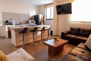 ein Wohnzimmer mit Küche mit Theke und Couch in der Unterkunft T - Apartamento Privado - Alegría Housing in Aguascalientes