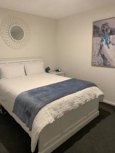 ジーロングにある7th Floor Apartmentのベッドルーム1室(壁に鏡が付いた白いベッド1台付)