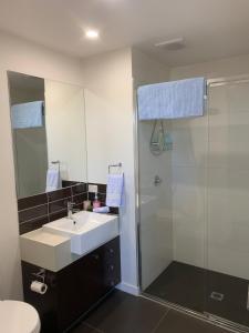 ジーロングにある7th Floor Apartmentの洗面台とシャワー付きのバスルーム +27枚の写真