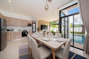 Una cocina y un comedor con mesa y sillas. en Kamala Sunshine Villa - Goldena Twin, en Kamala Beach