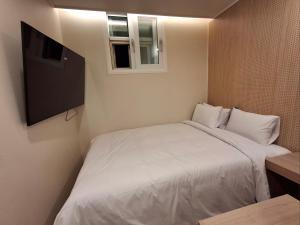 首尔Rio Hotel的一间带白色床和窗户的小卧室 更多37张照片