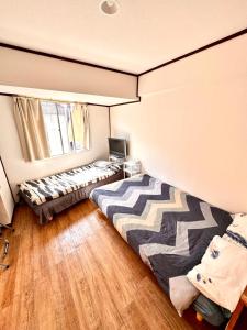 a bedroom with two beds and a window at Shinjuku Wasabi House II in Tokyo