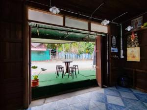 an open door to a patio with a table and chairs at Baan pai Hostel in Pai