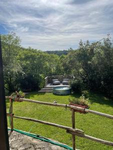 a backyard with a swimming pool and a fence at Casa nel bosco il Grottone in Montaione