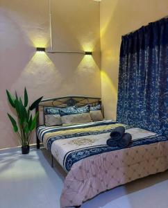 a bedroom with a bed with blue and white sheets at Natasha RestHouse in Pulau Langkawi