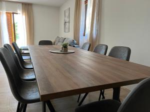 a dining room with a wooden table and chairs at Peaceful New Country House with Saltwater Pool in Brgud