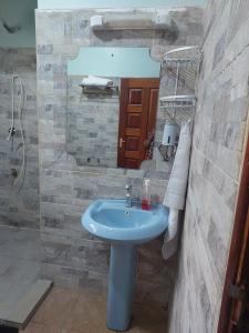 un bagno con un lavandino blu e uno specchio di Kukis Place in Embu a Embu Altre 9 foto