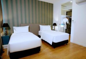 Rúm í herbergi á THE FACE Suites Hotel