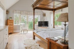 a bedroom with a canopy bed and a television at Inkerman House - Gorgeous House and Gardens in Fritwell