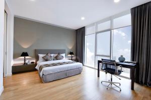 a bedroom with a bed and a desk and window at THE FACE Suites Hotel in Kuala Lumpur +39 photos