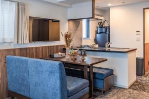 a kitchen with a table and a blue chair at Apartment Hotel 11 Abeno in Osaka