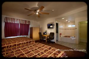 a bedroom with a bed and a ceiling fan at The Palace Inn in Oxnard