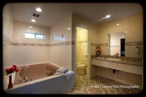 a bathroom with a large tub and two sinks at The Palace Inn in Oxnard