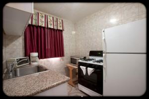 a kitchen with a white refrigerator and a sink at The Palace Inn in Oxnard