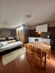 a kitchen with a table and a bed in a room at Hotel WIR in Rzgów