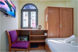a bedroom with a bed and a desk and a chair at NU House - Private Room in Heart of District 1 - Walk to Everything in Ho Chi Minh City