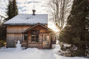 eine Hütte im Schnee mit Sonne in der Unterkunft Das Heinz in Puchen