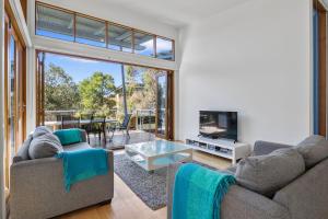 un salon avec deux canapés et une télévision dans l'établissement South Shores Villa 50, à Normanville