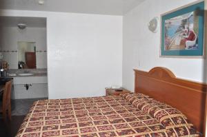 a bedroom with a bed and a sink in it at The Palace Inn in Oxnard