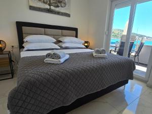 a bedroom with a large bed with towels on it at VILA KIKA in Rogoznica