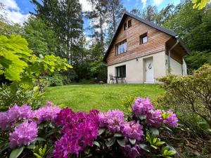 a house with purple flowers in the yard at Chalupa u Lacinů in Mirošovice
