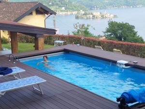 a woman in a swimming pool with a view of the water at B&B La Plesna in Pella