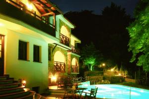 a house with a swimming pool at night at Kazaviti Luxury Suites in Mikrós Prínos