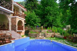a swimming pool in front of a house at Kazaviti Luxury Suites in Mikrós Prínos +31 photos