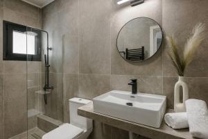 a bathroom with a sink and a mirror and a toilet at The Uptown Boutique Apartments in Athens +39 photos