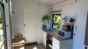 a kitchen with a counter with a microwave and a window at Ryan's Ranch by Tiny Away in Belgrove