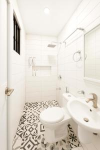 a white bathroom with a toilet and a sink at Modern and Stylish Bachelors Pad in San Josef