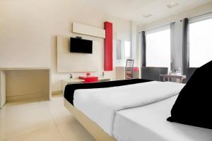 a bedroom with a white bed and a tv on the wall at Super Collection O by OYO Railway Station Amritsar Formerly Golden Home in Amritsar