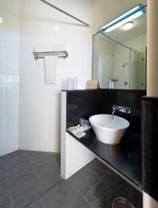 a bathroom with a sink and a mirror at Sparsa Resort Kanyakumari in Kanyakumari
