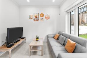 un soggiorno con divano e TV a schermo piatto di Modern Private 3BR House a Vancouver