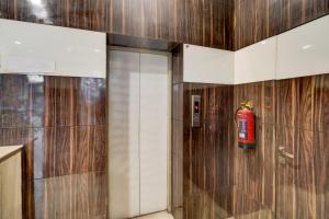 a fire extinguisher is on the wall of a bathroom at Collection O Sindhi Camp Bus Stand Formerly Hotel Metro View in Jaipur