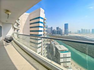 un balcon avec vue sur une ville dans l'établissement Silkhaus Modern 2 BDR | Sea View | Oceanscape, à Abu Dhabi 13 autres photos