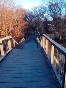 une passerelle sur un pont dans un parc dans l'établissement Darłówko 300m plaża Kładkowe Studio 1, à Darłowo