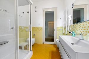Un baño con lavabo, ducha e inodoro. en Residence Virgilio Yellow, en Toscolano Maderno 18 fotos más