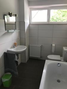a white bathroom with a sink and a toilet at Möbliertes Wohnen auf Zeit im Extertal in Extertal +3 photos