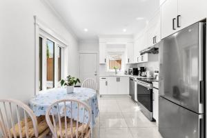 una cucina con tavolo, sedie e frigorifero di Modern Private 3BR House a Vancouver