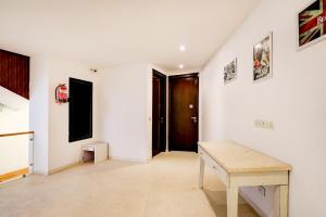 a room with white walls and a wooden table at Super Townhouse T Block Sector 24 in Gurgaon