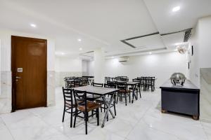a dining room with tables and chairs and a door at Super Townhouse T Block Sector 24 in Gurgaon