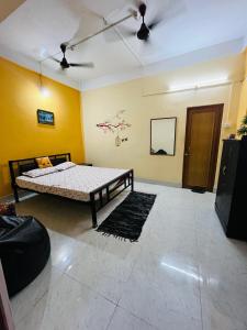 a bedroom with a bed in a room with yellow walls at SANGRAG Homestay in Guwahati