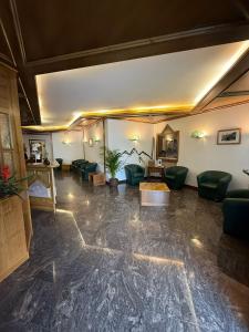 salon z zielonymi krzesłami i stołem w obiekcie Hotel Quadrifoglio w mieście Pinzolo