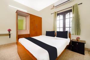 a bedroom with a large bed and a window at Hotel O Singanallur Coimbatore in Coimbatore